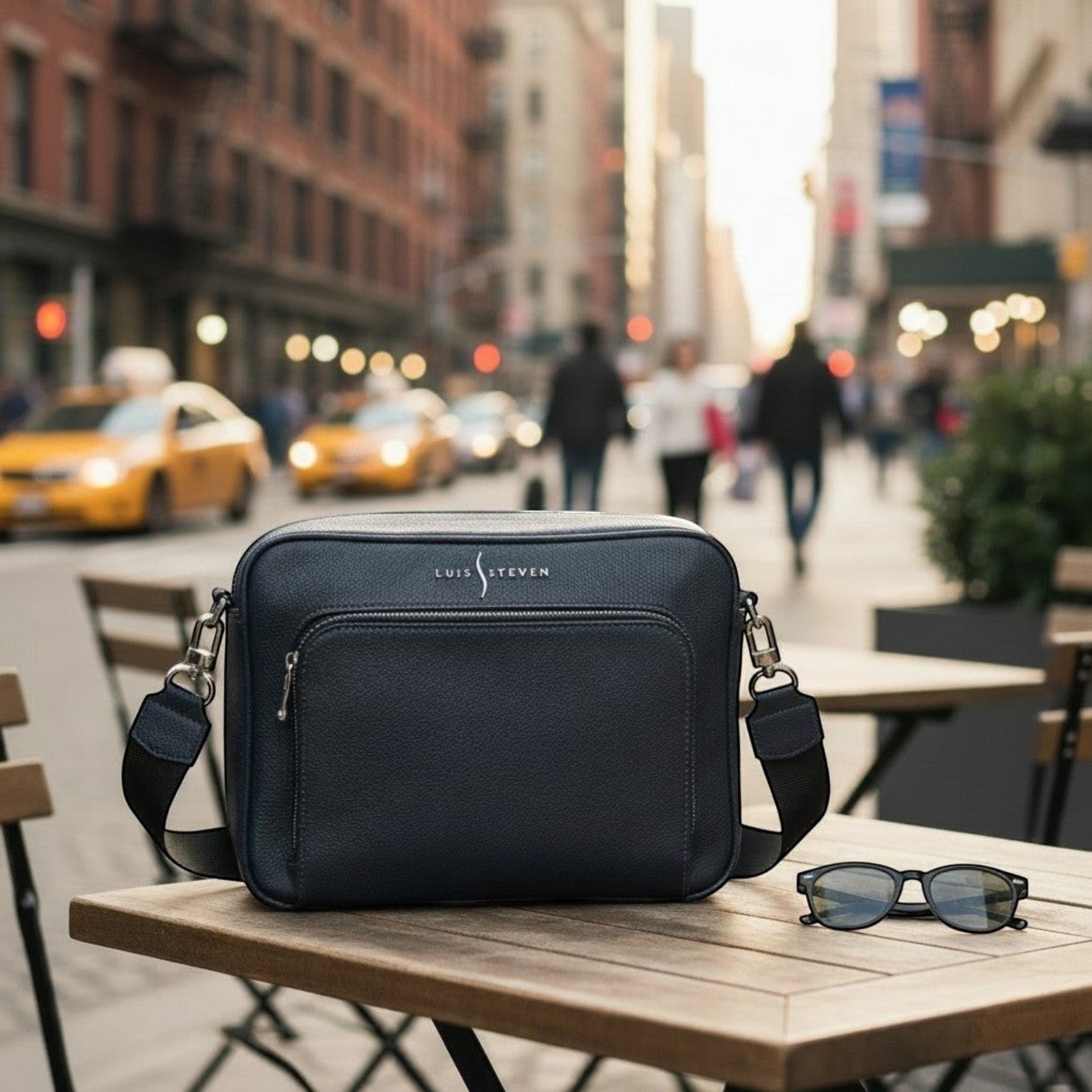 Luis Steven midnight blue pebble leather messenger bag with front organizer and crossbody strap, set on a table.