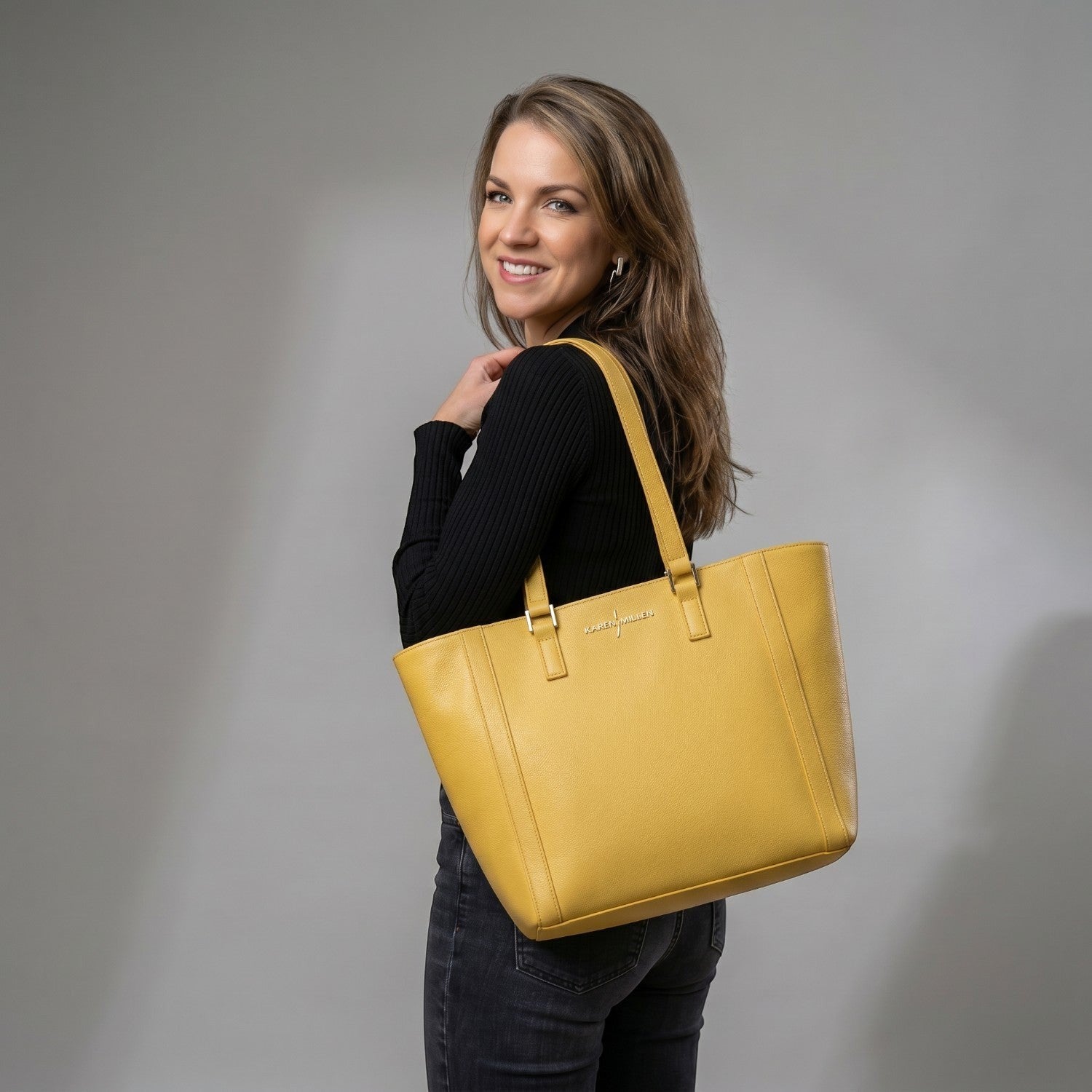 Luis Steven yellow pebble leather classic tote bag with gold hardware and zipper closure, worn by a woman on a city street.